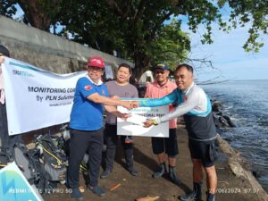 General Manager PLN UID Suluttenggo Patar Situmorang saat menyerahkan bantuan konservasi terumbu karang kepada perwakilan Boboca Diving Club, Nelson Uada (21/06).