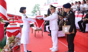 (Pj Bupati Mitra saat menyerahkan bendera merah putih)