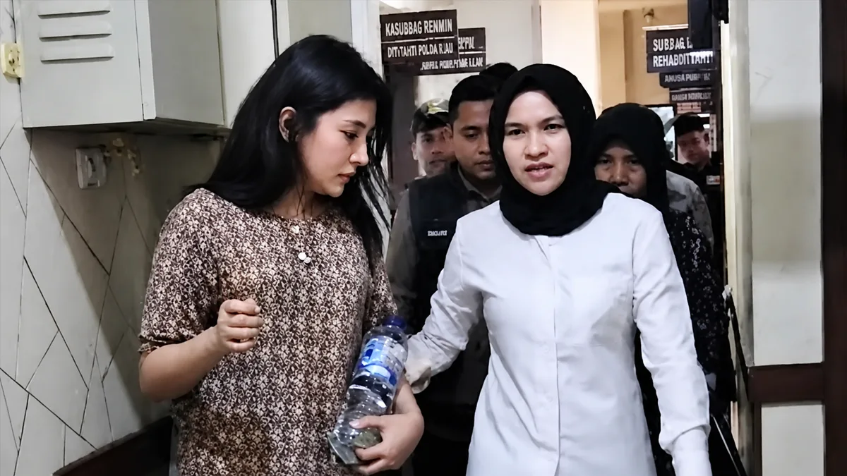Jeni Rahmadial Fitri (kiri) saat dibawa ke Markas Polda Riau.